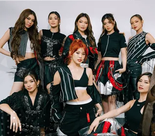 Vibrant K-pop girl group in stylish coordinated outfits perform on stage, showcasing modern fashion, music, and dance talent,