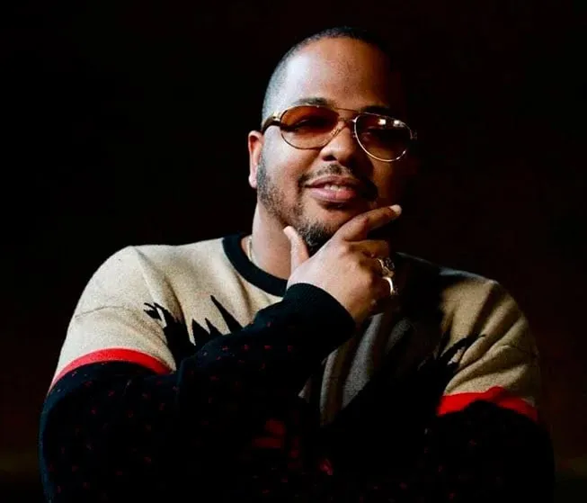 Someone thinking creatively, wearing sunglasses and a casual sweater, with a confident expression, symbolizing innovative ide