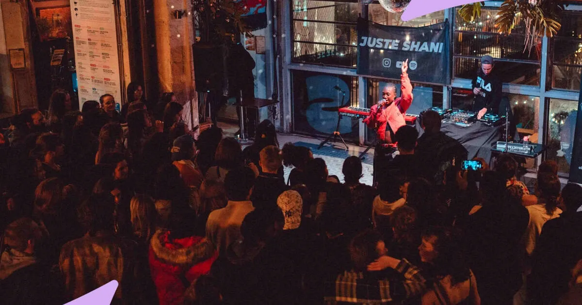 Live music performance at a bustling nightclub, featuring a singer with a microphone and a DJ playing electronic music, with