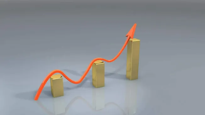 Rising business growth with increasing sales and revenue chart, orange arrow and gold bars representing financial success, in