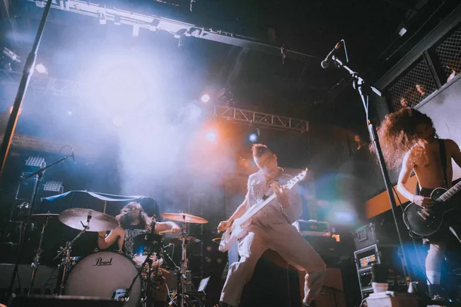 Energetic live band performing on stage with colorful lighting, showcasing vibrant music scene, talented musicians, and conce