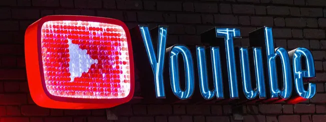 Red and blue neon YouTube logo sign with brick wall background, popular for digital content, social media branding, and onlin