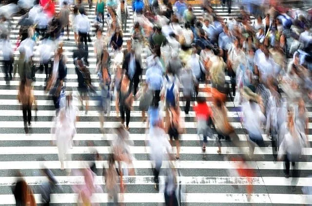 Crowded pedestrian crosswalk in an urban setting, symbolizing busy city life and foot traffic.
