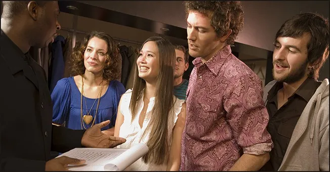 Band of diverse young people listening attentively during a discussion or presentation in a casual setting, emphasizing music