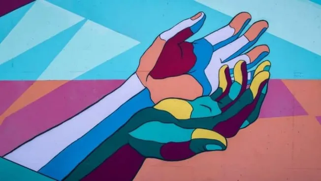Hand-painted illustration of two hands clasped together, featuring vibrant, bold colors and geometric patterns, representing
