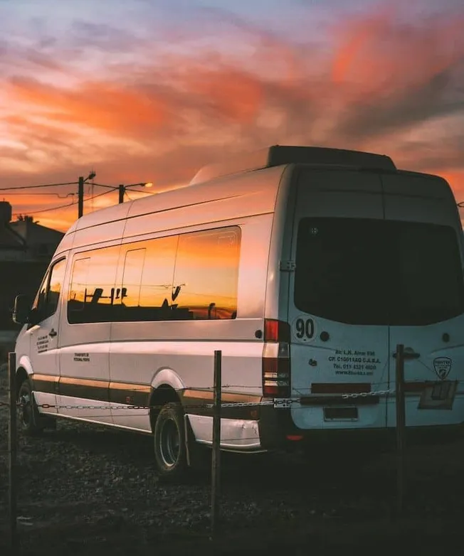 Hypebot, sunset reflection on white van, urban sunset scene, transportation, reflective vehicle, evening sky, city backdrop,