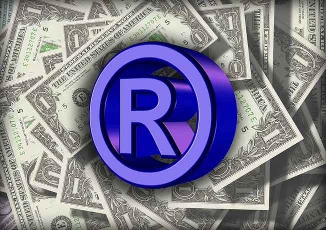 Registered trademark symbol on dollar bills, representing monetization and branding in the music industry.