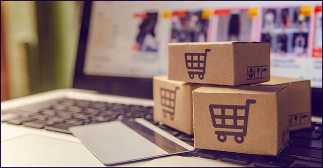 3D shopping cart cardboard boxes representing e-commerce logistics on a laptop keyboard, illustrating online retail, digital