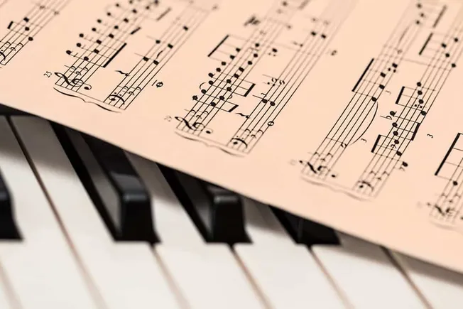 Music sheet and piano keyboard close-up, musical composition on paper, artistic and creative music production, attention to d