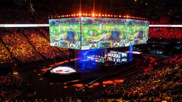 Vibrant esports arena with large LED screens displaying gameplay, surrounded by enthusiastic fans, emphasizing live gaming ev