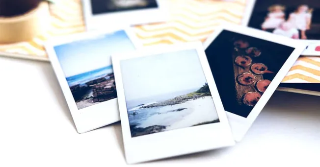 Colorful instant photos scattered on a table, capturing moments of nature, food, and friends, perfect for travel albums or so