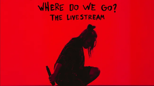 Shot of a female musician with a microphone in hand, kneeling on stage with a red background, promoting livestream concert an