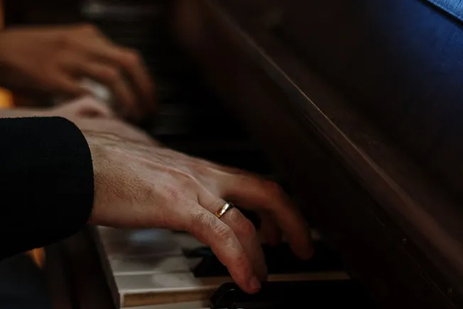 A close-up of hands playing piano, showcasing passion for music and musical talent.
