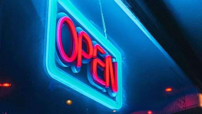 Neon open sign with bright red and blue colors indicating business hours, attracting customers to the store or restaurant.
