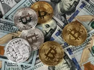 Gold and silver Bitcoin coins on US dollar bills, cryptocurrency, digital currency, blockchain technology, financial investme