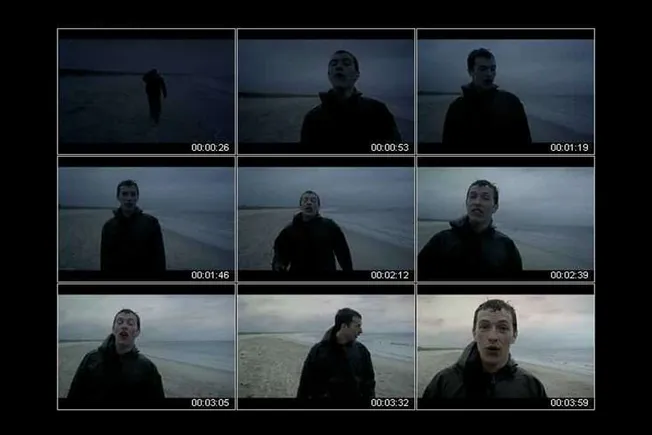Beach scene with young man in dark clothing at dusk, moody ocean landscape, cinematic shots, emotional tone, tall and short s
