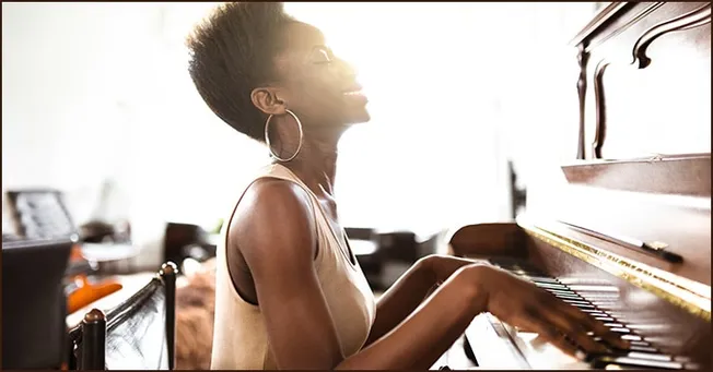 Piano playing woman in sunlight, joyful female pianist, practicing music at home, expressive music performance, elegant woman