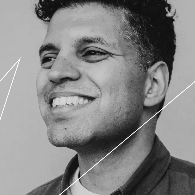 Smiling man portrait in black and white, showcasing happiness and confidence for music industry or entertainment branding.