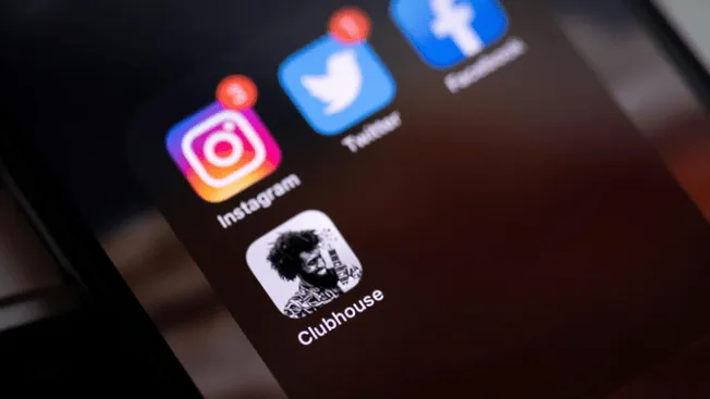 Instagram, Twitter, Facebook, and Clubhouse app icons on a smartphone screen, representing social media platforms used for ma
