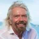A smiling man with white hair and a beard enjoying a sunny outdoor setting, representing positivity and well-being.