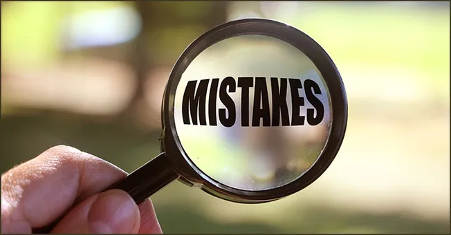 Mistakes written on a magnifying glass to symbolize error detection and analysis in business or creative projects.