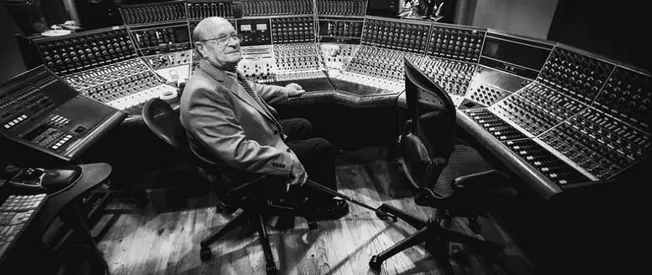 Highly detailed professional audio mixing console in a recording studio with a sound engineer, capturing the essence of music