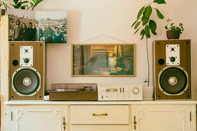Modern home audio system with vintage speakers, turntable, and framed photos, showcasing music and entertainment setup for a
