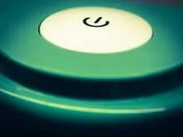Power button illuminated on electronic device, symbolizing startup or power on.