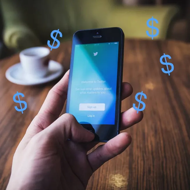 Twitter app on smartphone screen with dollar signs overlaid, representing social media monetization and digital marketing str