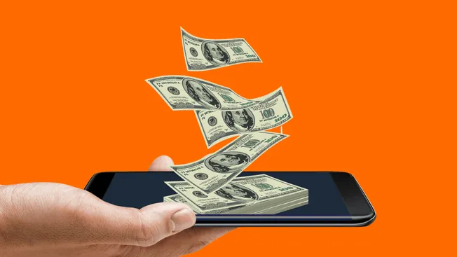 Mobile phone with digital dollar bills flying out, symbolizing online income, digital payments, or mobile money transfer.