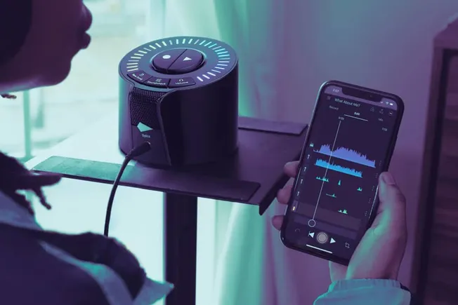 Portable Bluetooth speaker connected to a smartphone with music editing app, highlighting music streaming, audio technology,