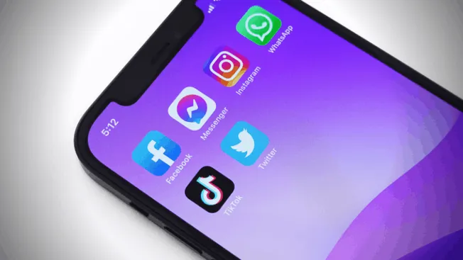 Instagram, Facebook, TikTok, Twitter, Messenger, and WhatsApp app icons on a smartphone screen, representing social media pla
