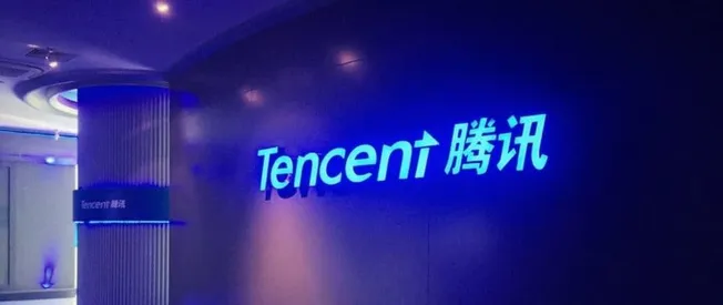Tencent logo illuminated on a modern corporate wall, representing a major technology and social media company, emphasizing in