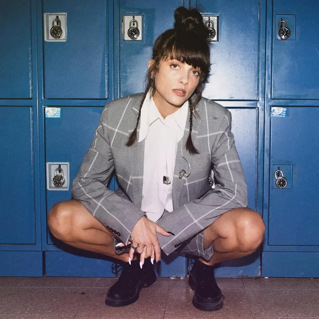 Lockers, woman in plaid suit crouching in front of lockers, trendy fashion, urban style, casual look, youth culture, music an