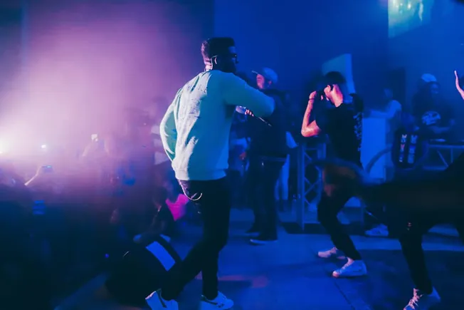 People dancing at a vibrant nightclub with colorful lighting and energetic atmosphere.