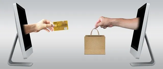 Online shopping transaction between two computer screens showing credit card and shopping bag, e-commerce, digital marketplac
