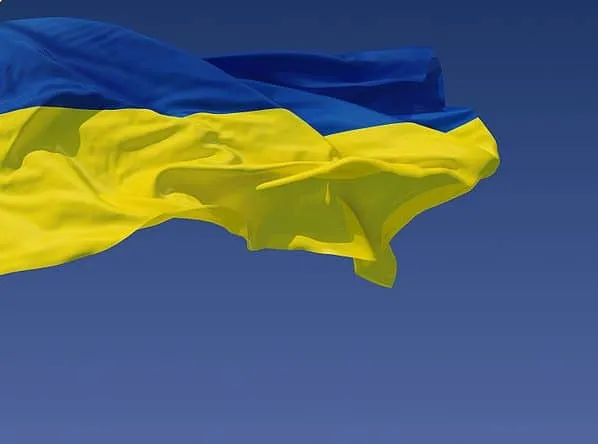 A Ukrainian flag waving against a clear blue sky, symbolizing national pride and resilience.