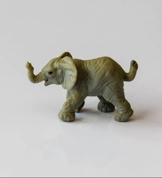 Small toy elephant with exaggerated features and a squeaky trunk on a plain white background.