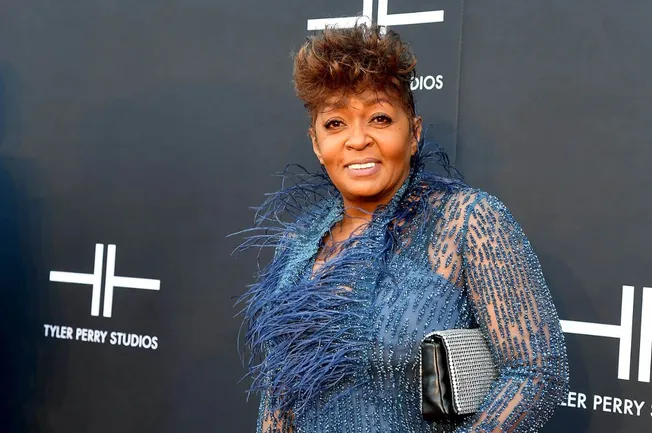 Elegant woman in a glamorous blue dress with feather details attending a Tyler Perry Studios event, showcasing celebrity fash