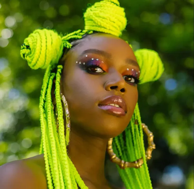 Vibrant neon green braided hairstyle with decorative beads and makeup, showcasing bold jewelry and artistic beauty look, set