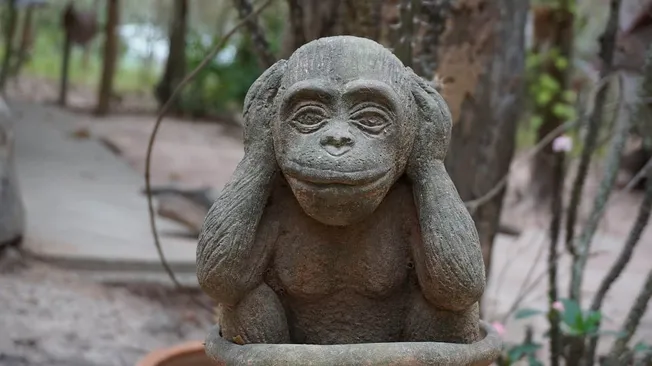 Ancient stone monkey sculpture strategically positioned in a lush forest setting, symbolizing nature-inspired art and cultura