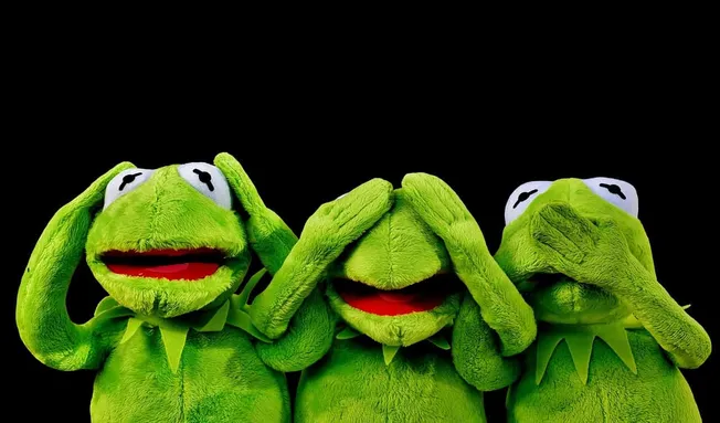 Bright green Kermit the Frog plush toys representing the "see no evil, hear no evil, speak no evil" concept on a black backgr