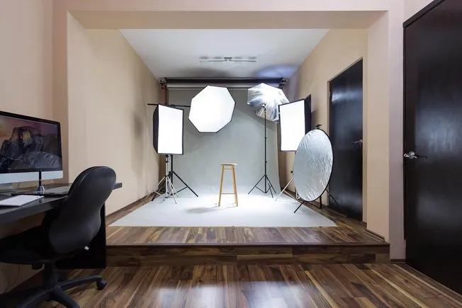 Professional photography studio with lighting equipment and a minimalist setup for video and photo shoots.
