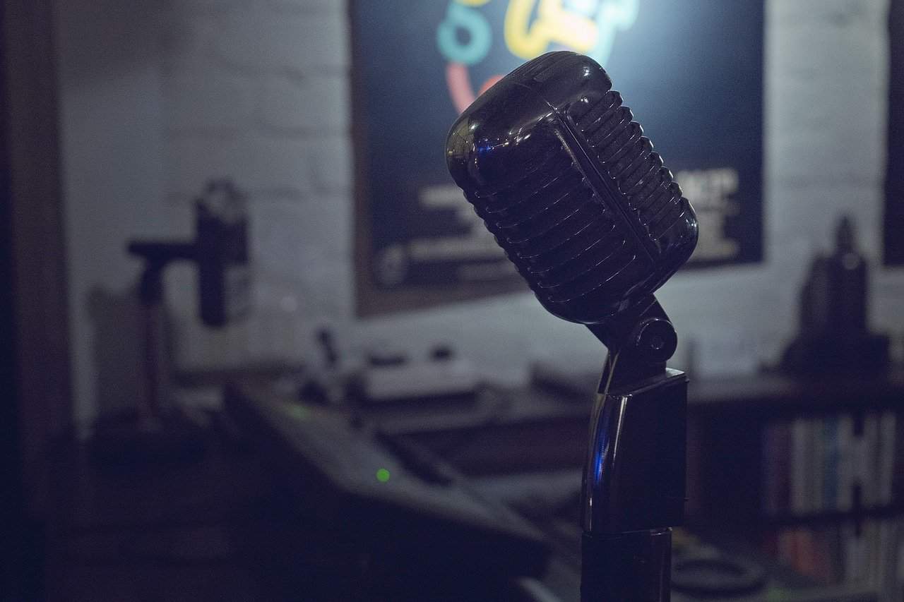Microphone on a stand in a recording studio or podcast setup, professional audio equipment, music production, Hypebot, recording technology, podcasting, music industry insights.