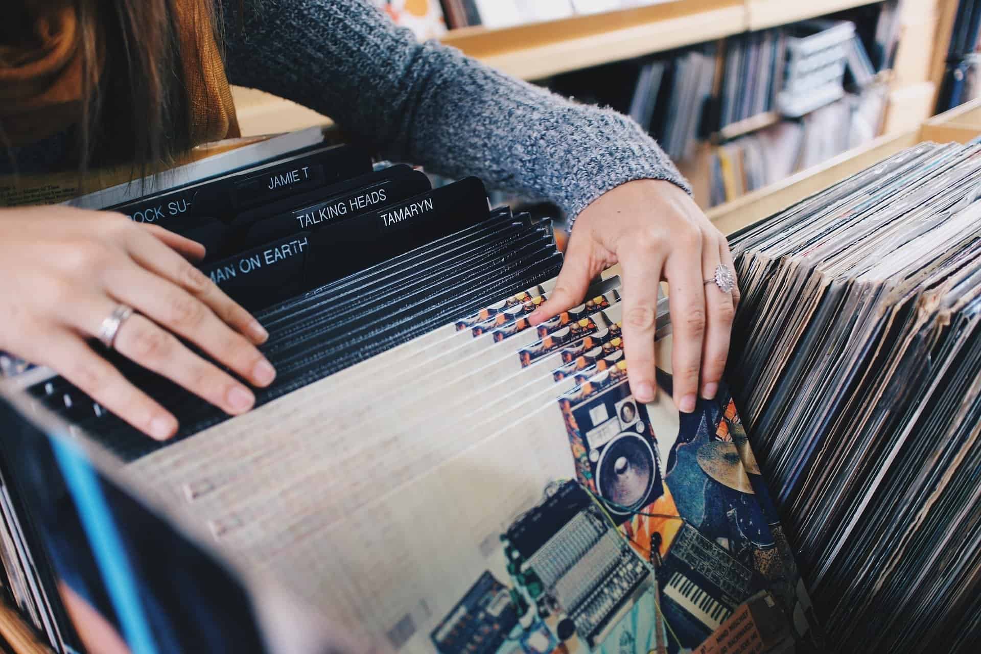 Vintage vinyl record collection organized in a wooden crate with record labels like "Talking Heads" and "Tame Impala" visible, perfect for music enthusiasts and collectors.