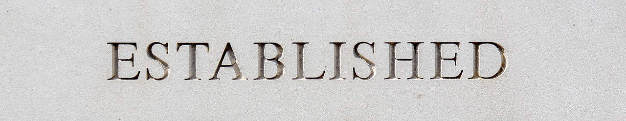 Established word engraved on a stone surface, symbolizing stability and tradition.