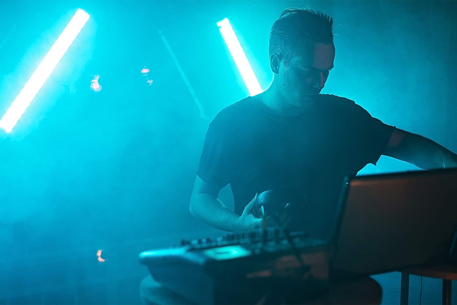 Futuristic DJ performing live with vibrant blue neon lights, blending electronic music and digital DJ culture, ideal for music industry, nightlife, and performance event SEO.