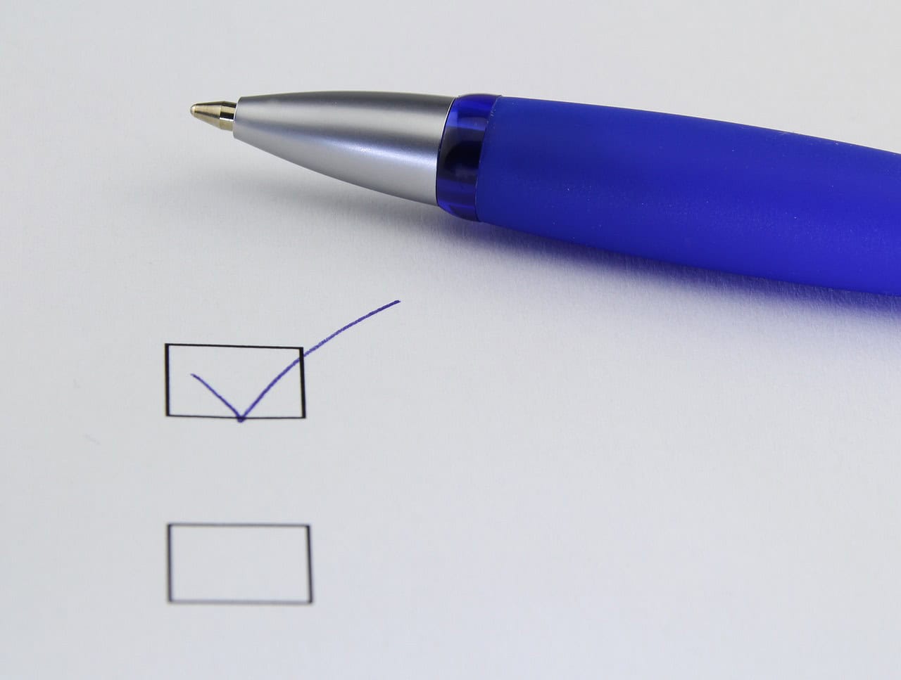 Blue pen checking off a box on a checklist, close-up of a writing instrument and completed task, business and productivity, Hypebot image for music industry insights and marketing strategies, digital media analysis.