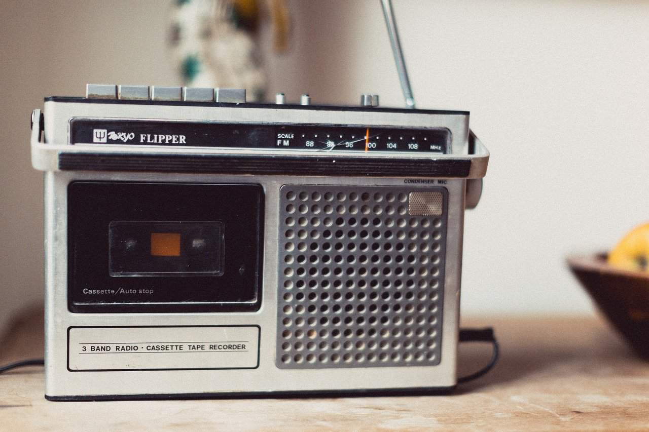 Retro 3-band radio cassette tape recorder, vintage portable music player with FM radio, old-school stereo audio device on wooden surface, nostalgic music technology, classic entertainment equipment.