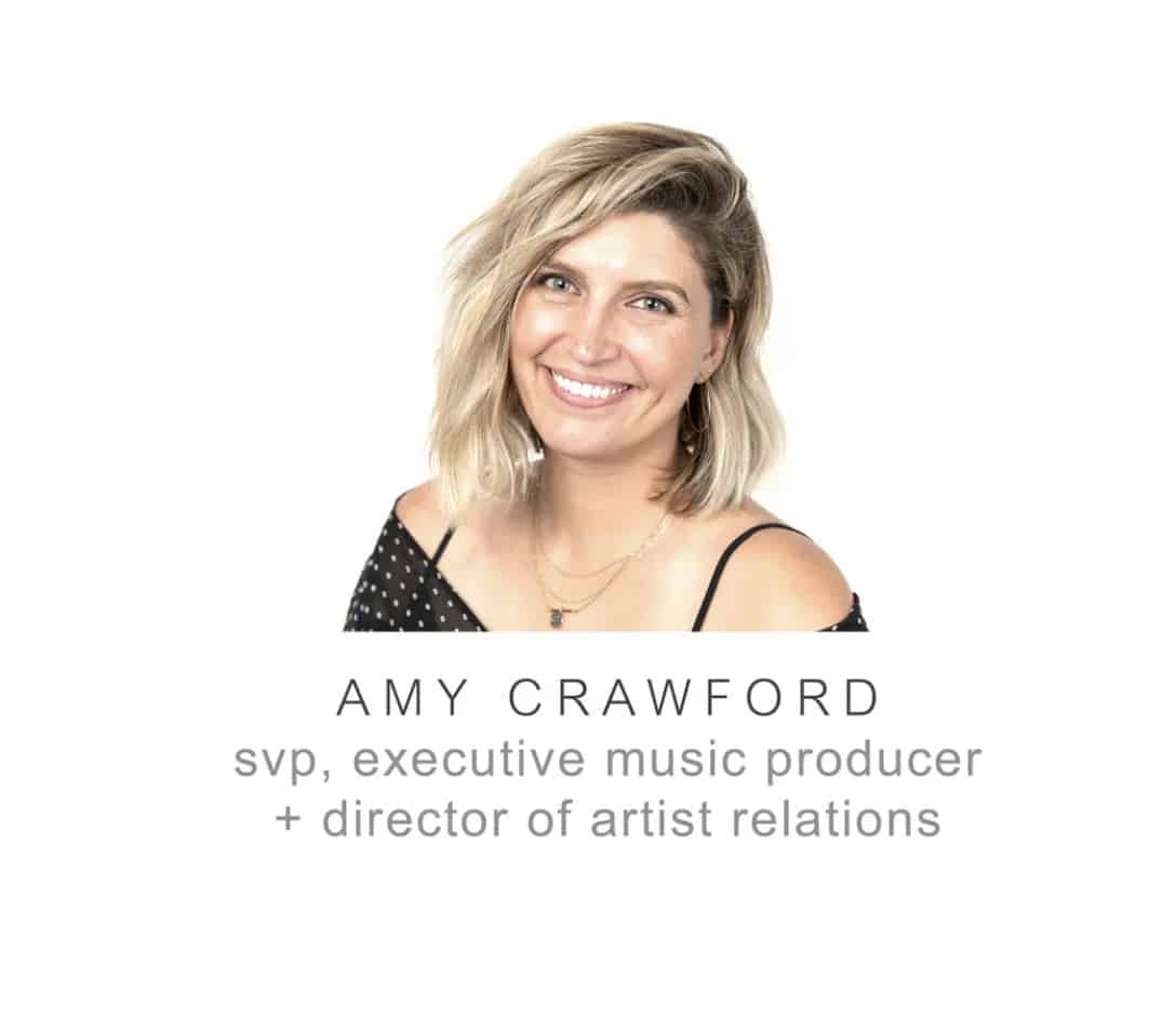 Professional headshot of Amy Crawford, SVP and executive music producer, smiling, wearing a black polka dot top, representing expertise in music industry, artist relations, and music production.